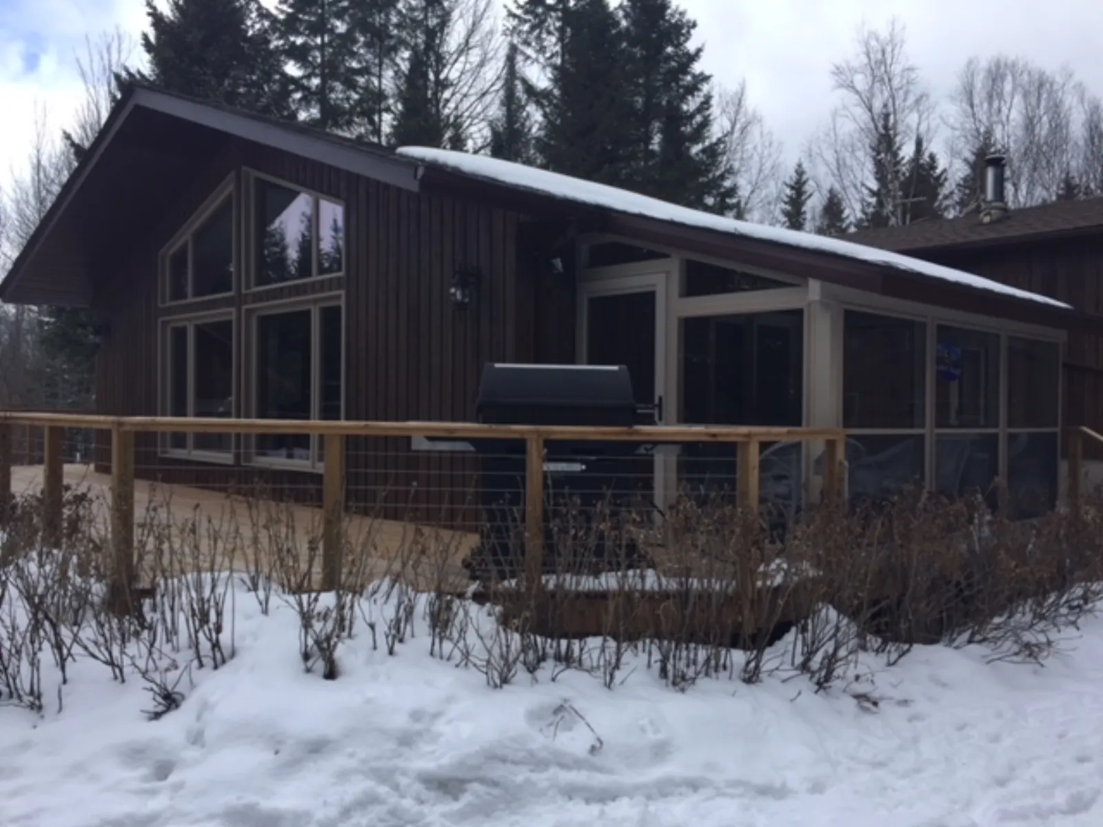 Modern dark cottage with timber deck in North Bay
